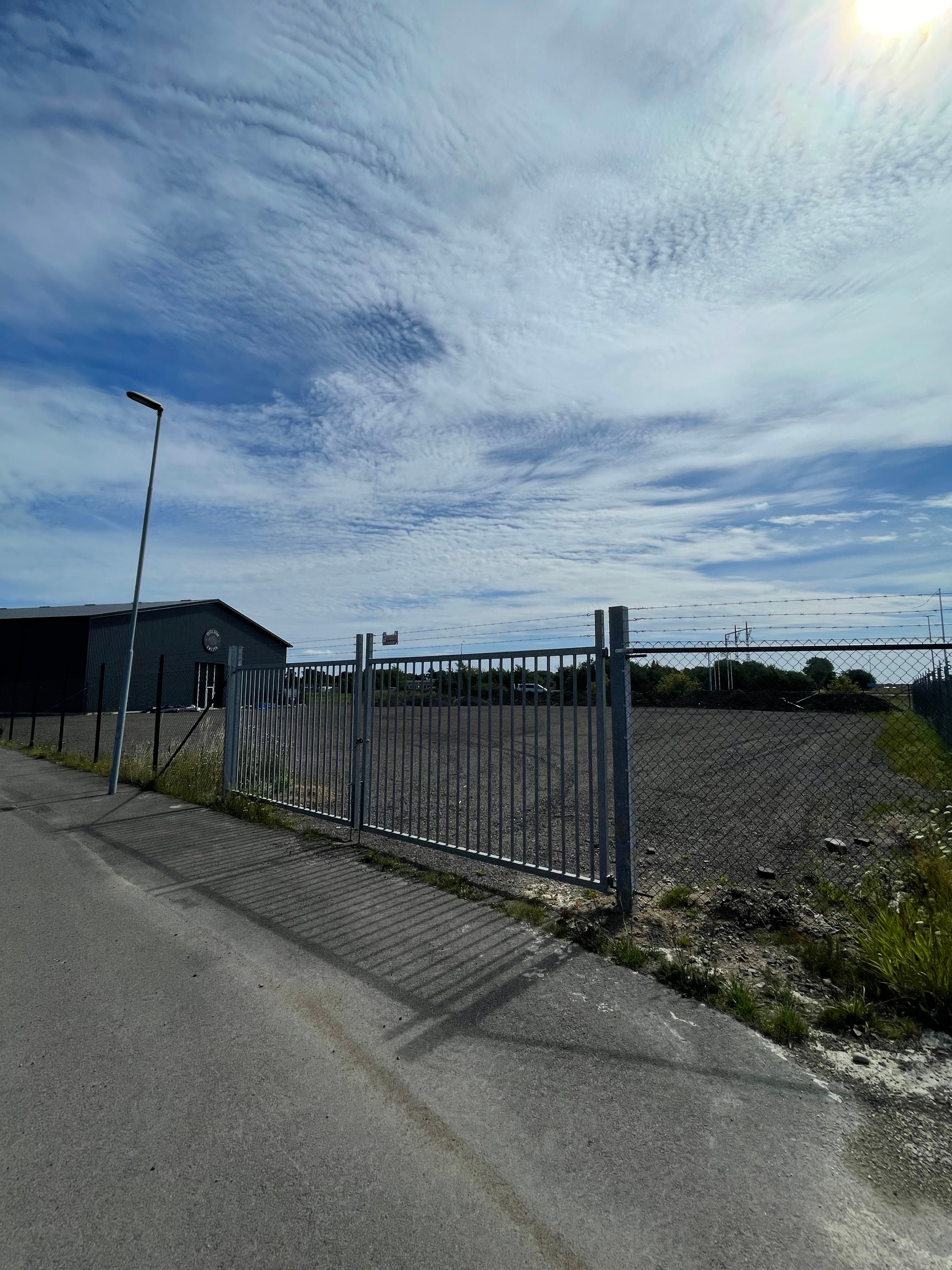 Översikt över inhägnaden med grinden i förgrunden.
